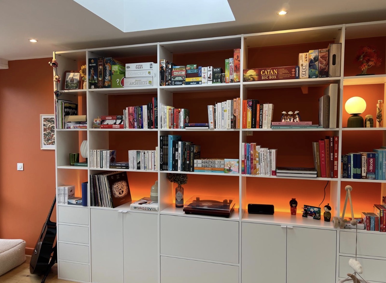 Mur orange et bibliothèque sur mesure